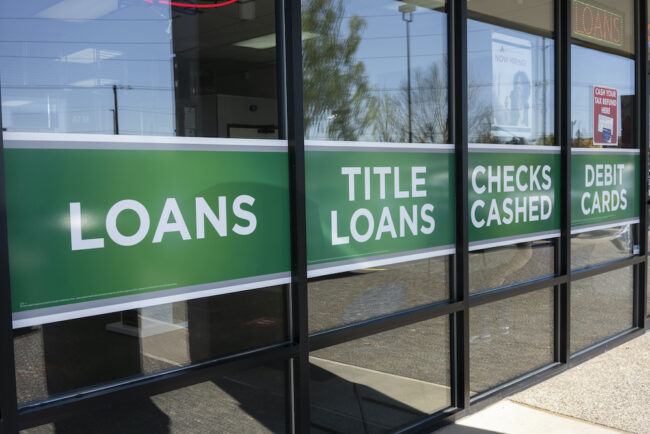 Tigard, OR, USA – Apr 16, 2021: Loans, title loans, checks cashed, debit cards – storefront advertisements are seen at an ACE Cash Express location in Tigard, Oregon.